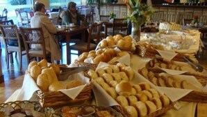 A buffet table with various breads and pastries. - Tri Hotel Executive Caxias (Caxias do Sul)