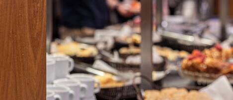 A buffet with various food items and utensils.