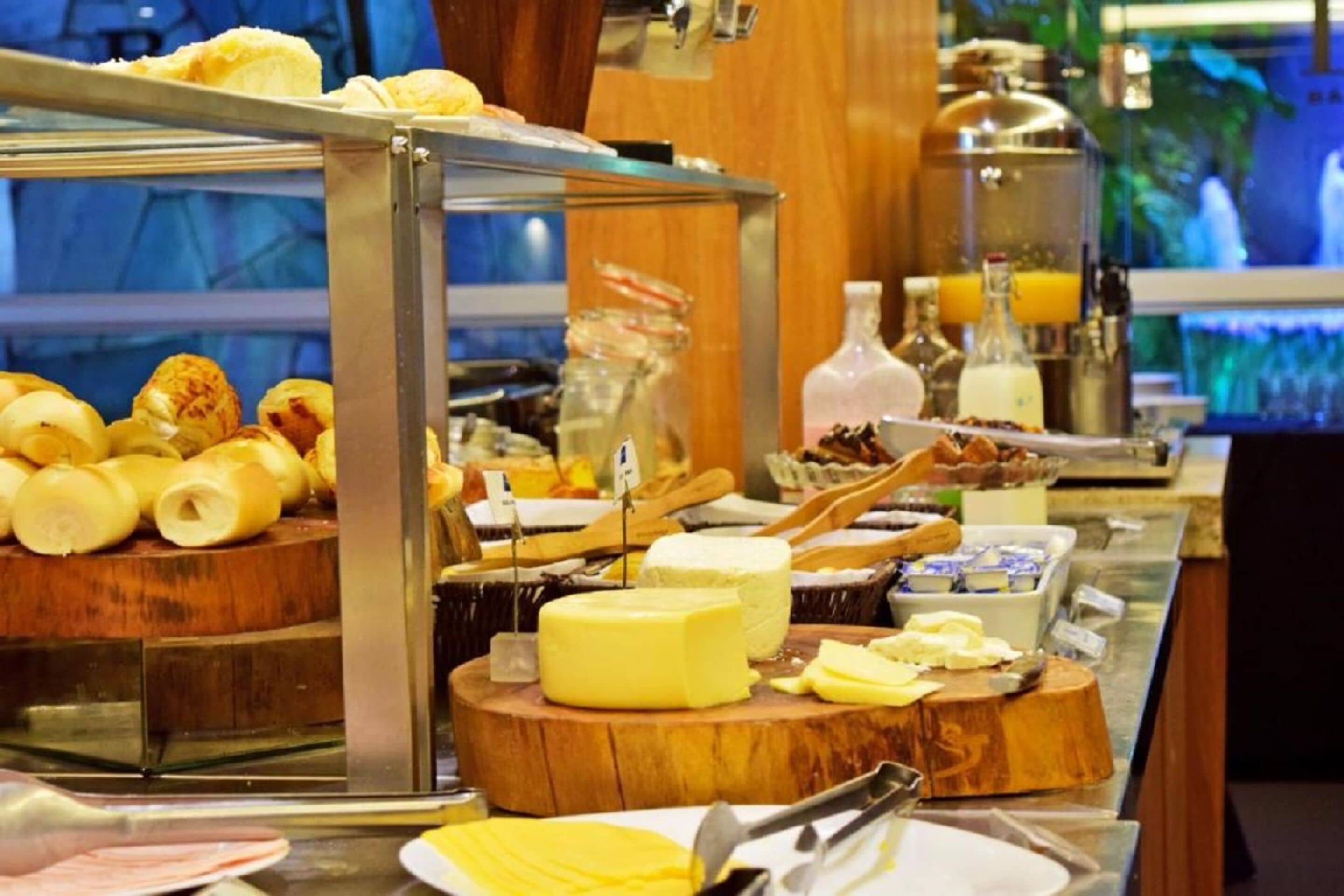 A buffet with various food items including cheese, fruits, and condiments.
