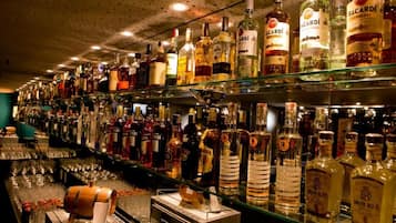 A bar with shelves stocked with various liquor bottles.
