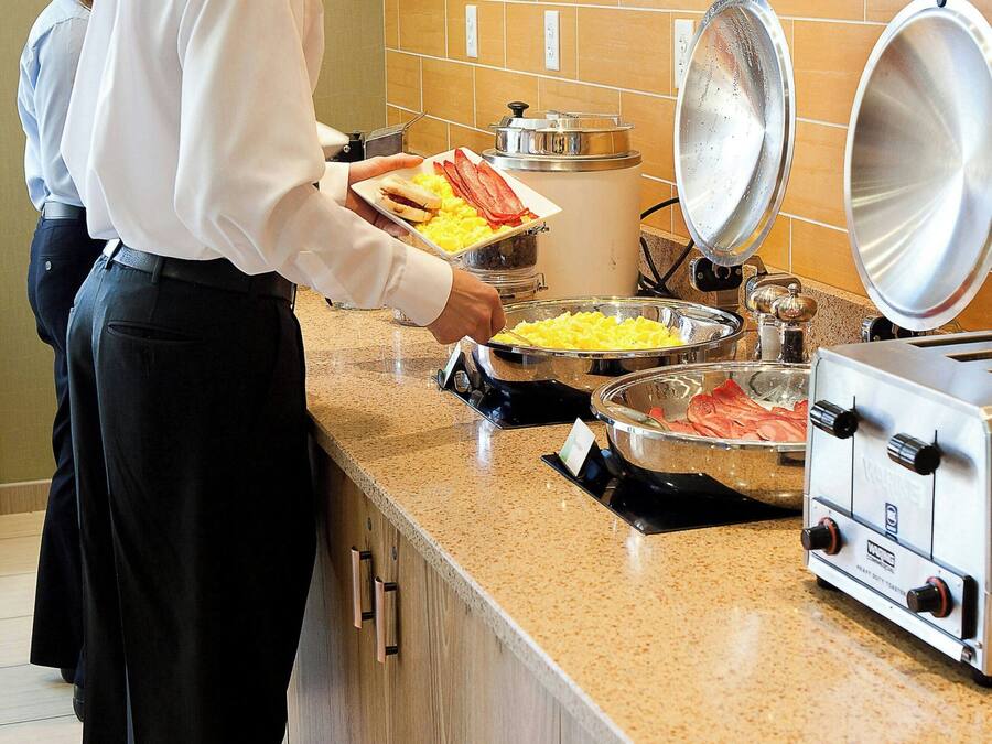 A buffet setup with various food items and a stove.