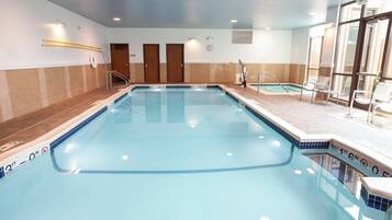 A swimming pool with a 3ft depth marker, a bench, and an exit sign.
