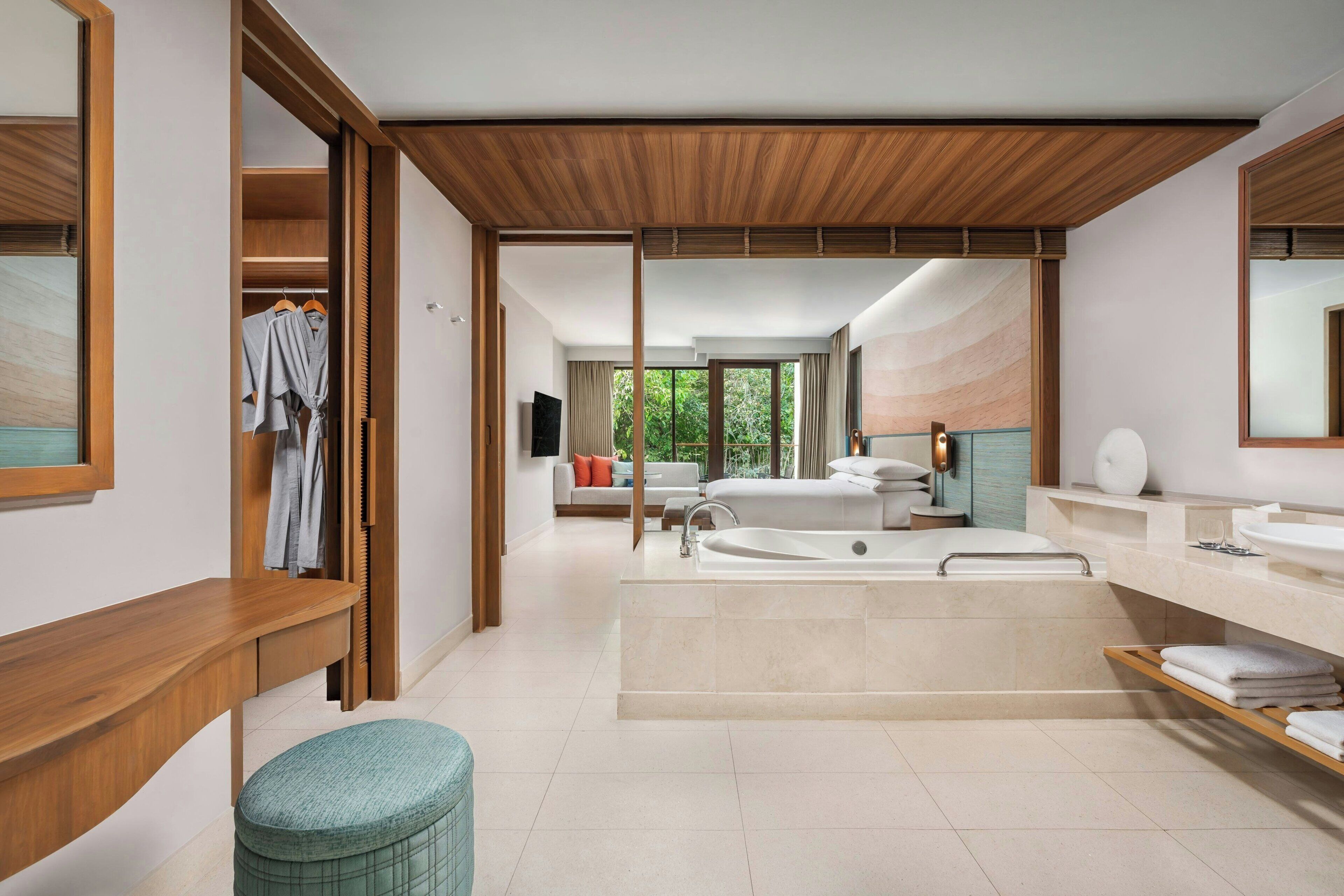 A modern bathroom with a large bathtub, a separate shower area, and a vanity with a sink and mirror.