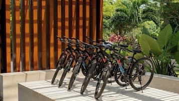 Un espace extérieur abrité, avec une rangée de vélos garés sous un toit en lattes de bois.