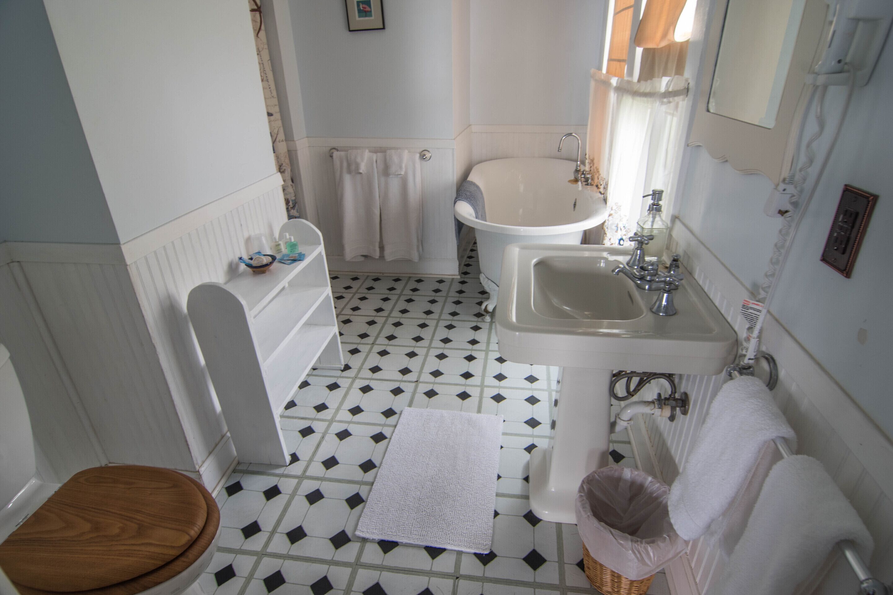 A bathroom with a toilet, sink, bathtub, and a tiled floor.