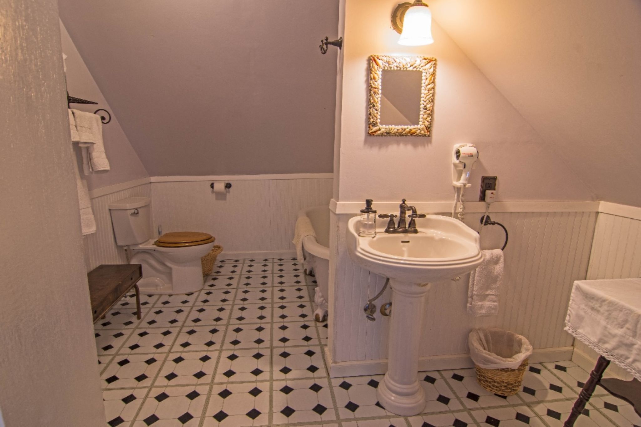 A bathroom with a toilet, sink, and mirror.