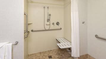 Chuveiro acessível para pessoas com deficiência, com barras de apoio, cortina de chuveiro branca e piso revestido de azulejos.