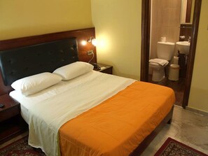 A hotel room with a bed, nightstand, and a bathroom visible through an open door. - Hotel Filoxenia (Chania)