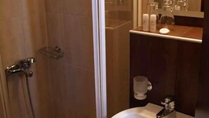 A bathroom with a shower, sink, and mirror. - Hotel Filoxenia (Chania)