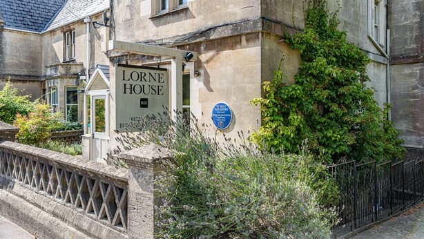 Un edificio de piedra con un cartel que dice "Lorne House" y una placa que indica que es un bed and breakfast.