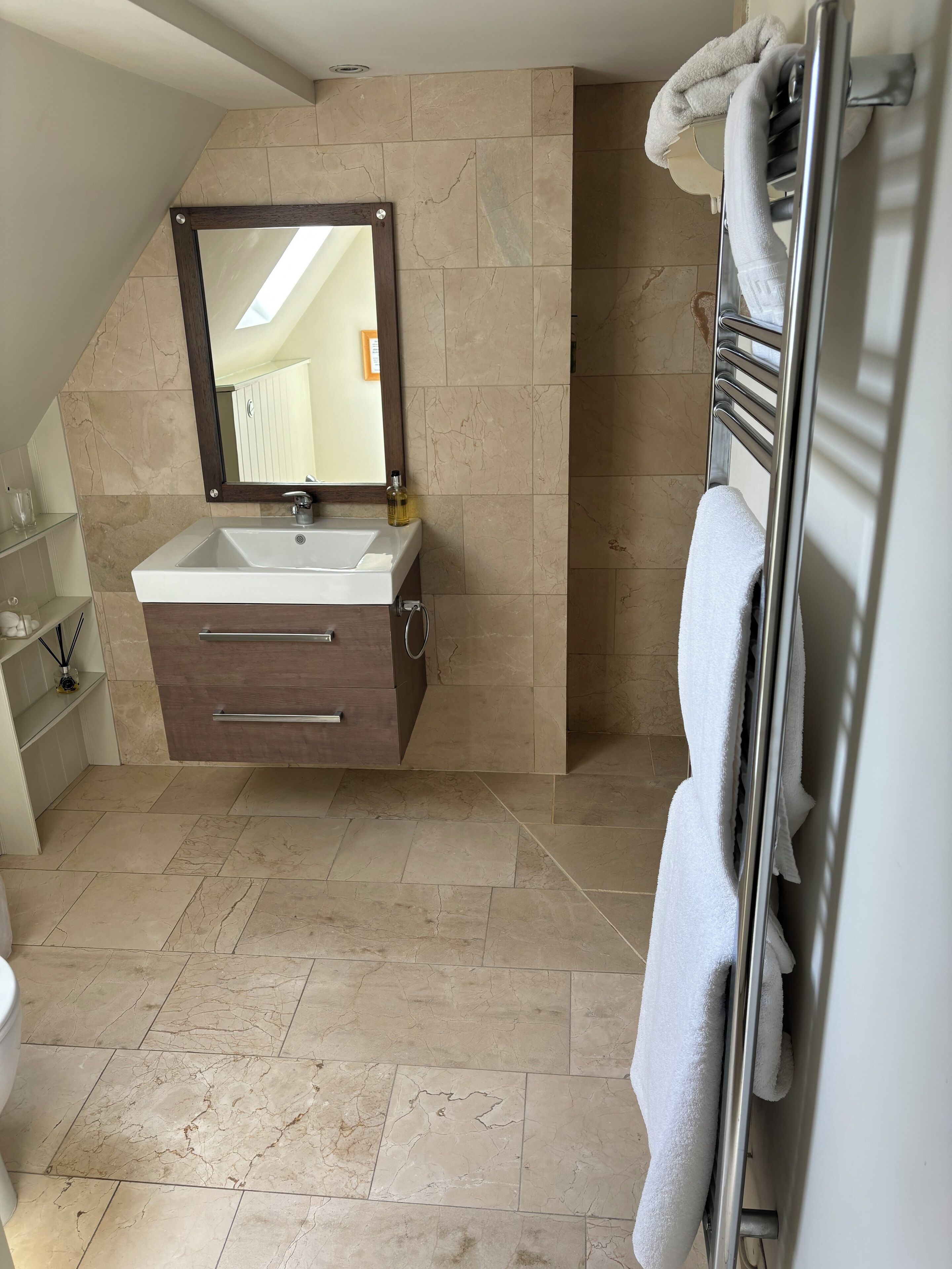 A modern bathroom with a built-in sink, a mirror, and a towel rack.