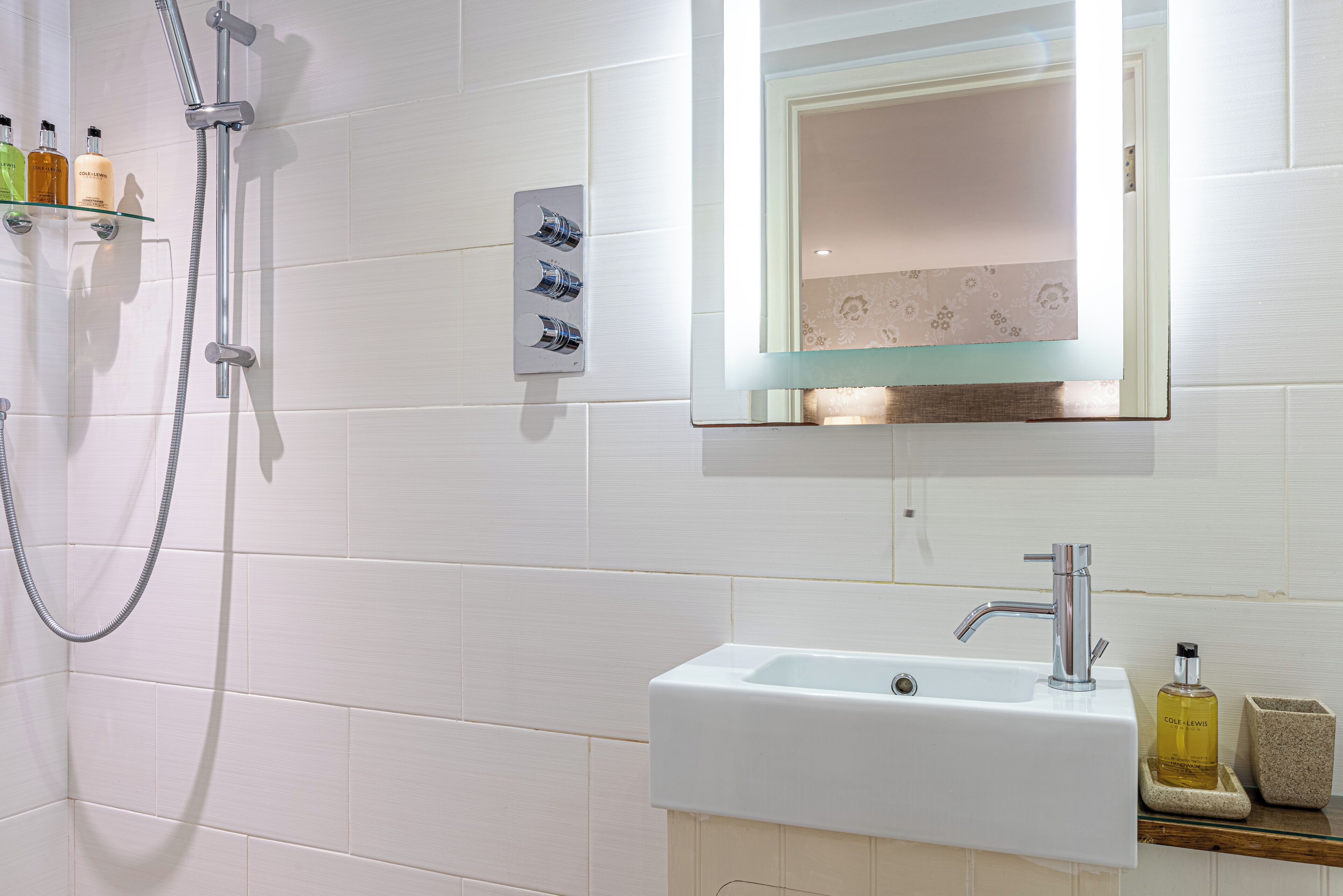 A bathroom with a shower, a sink, and a mirror.