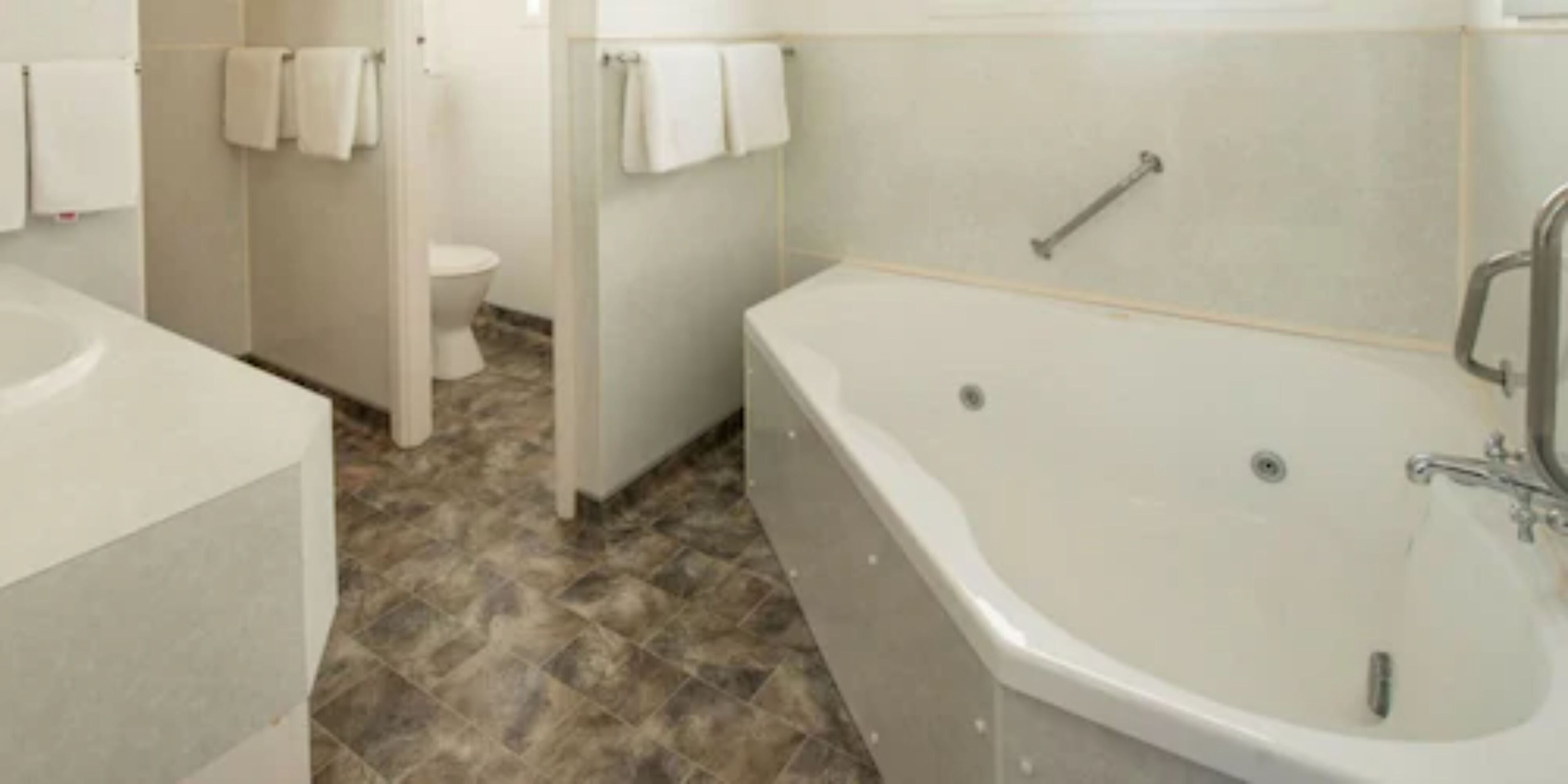 A bathroom with a bathtub, toilet, and sink.