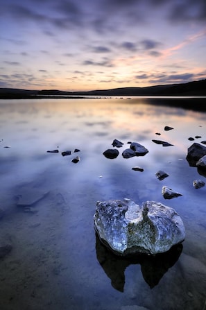 A calm lake with rocks and a sunset. - Beck Hall (Skipton)