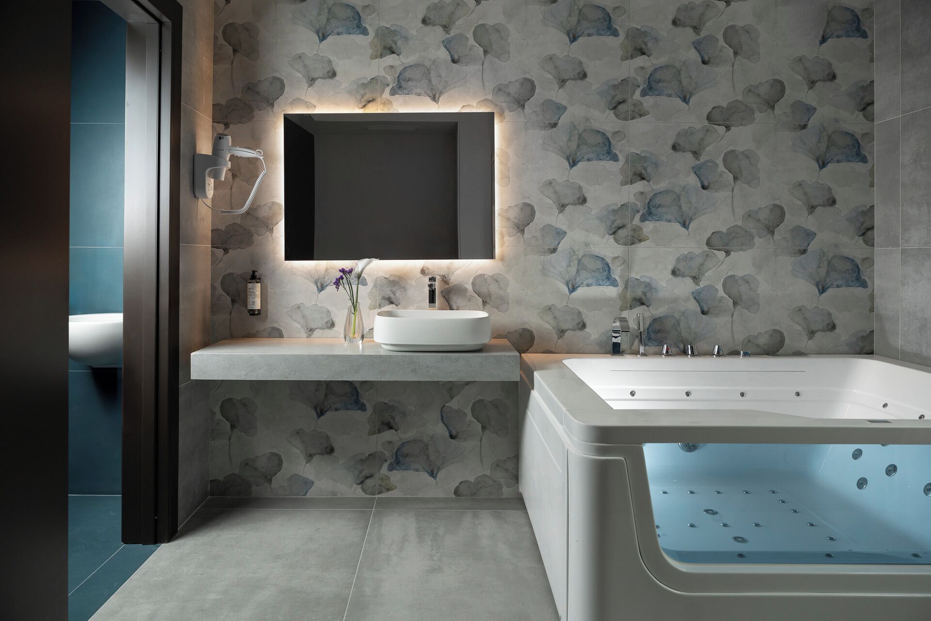 A modern bathroom with a freestanding bathtub, a round sink, and a mirror above the sink.