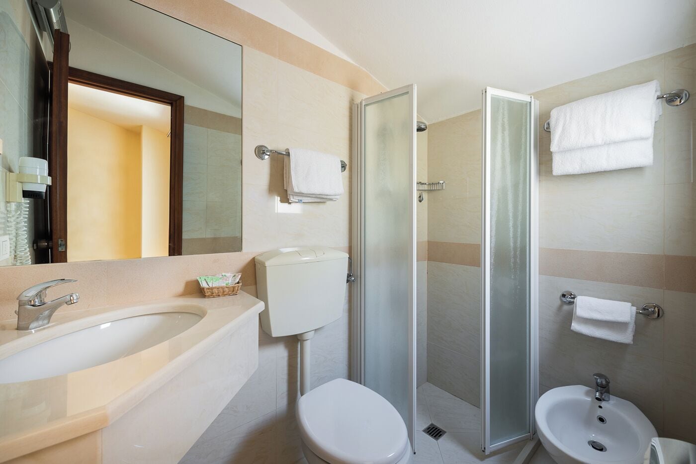 Un bagno moderno con un lavandino grande, il water e la zona doccia.