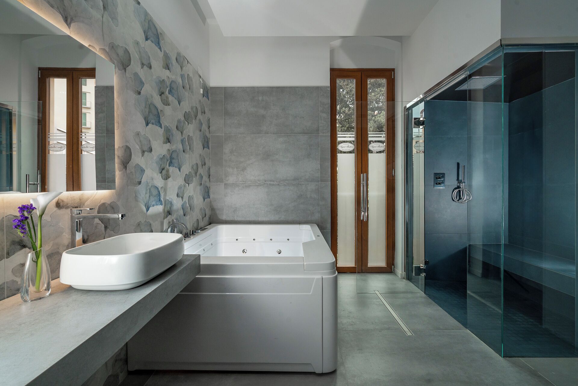 A modern bathroom with a freestanding bathtub, a large mirror, and a glass shower enclosure.