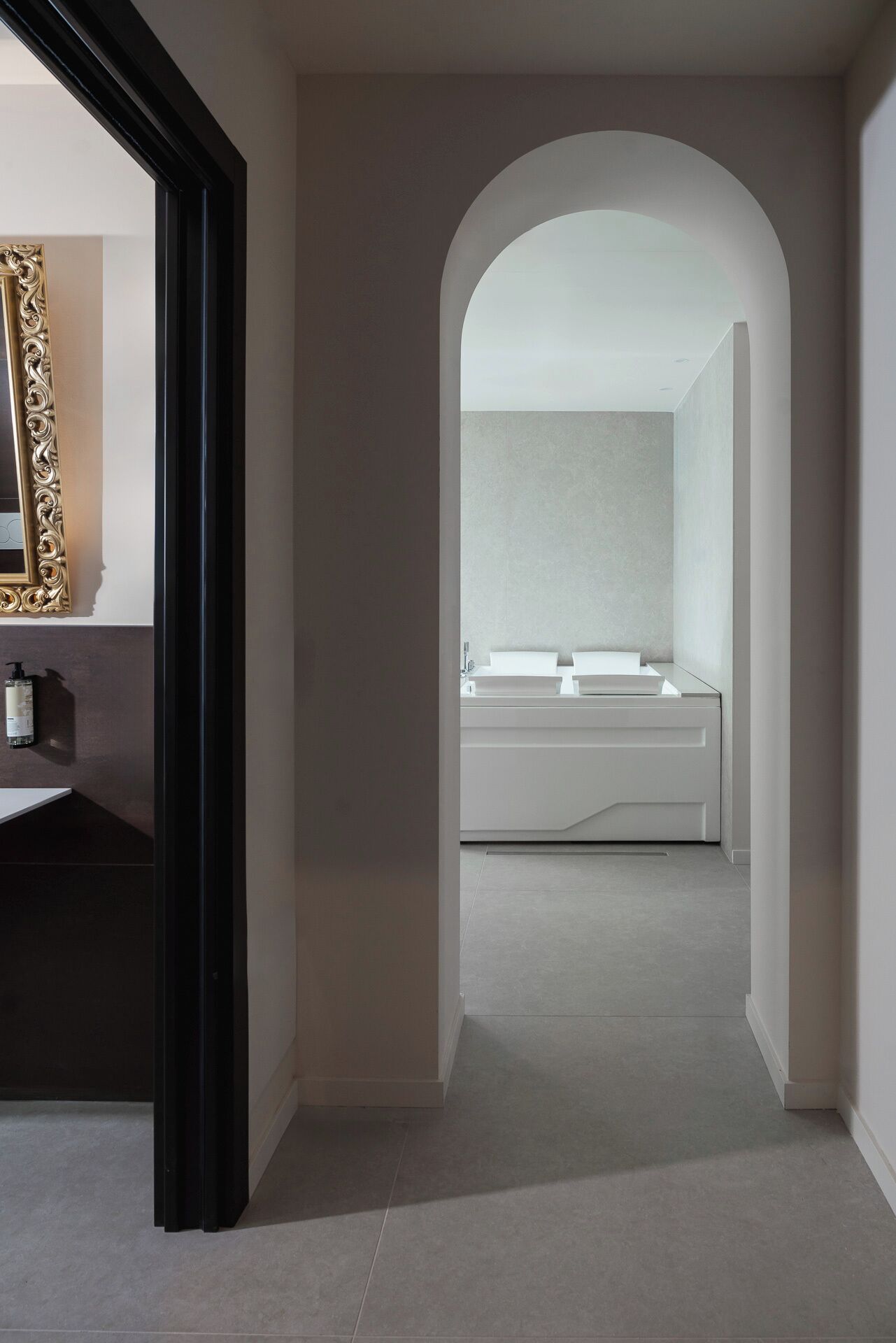 A modern bathroom with a minimalist design, featuring a large mirror, a white sink, and a sleek vanity.