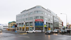 Un edificio moderno con un letrero que indica '101 Guesthouse' y servicios de 'City Car Rental'.