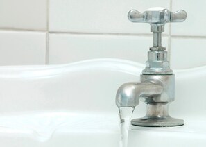 A bathroom with a chrome faucet and a white tiled wall. - Atholl Arms Hotel (Pitlochry)