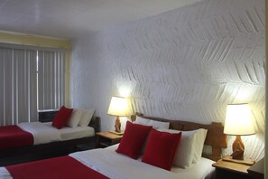 Ein Hotelzimmer mit zwei Betten, jeweils mit rot-weiß gestreifter Bettwäsche, und zwei Nachttischlampen.