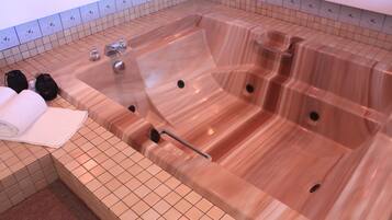Una grande vasca idromassaggio trasparente con diverse zone relax e un pannello di controllo.