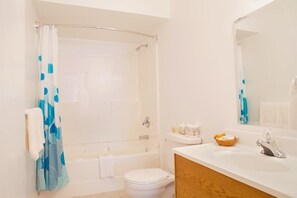 A bathroom with a bathtub, toilet, and sink. - Somass Motel (Port Alberni)