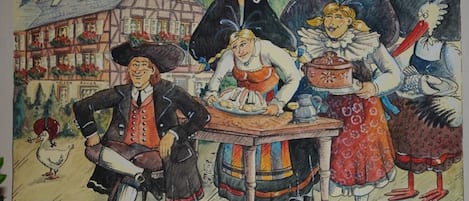 A traditional European building with a half-timbered facade, a wooden table, and a person in period attire.