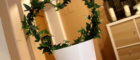 A white pot with a wreath of green leaves.