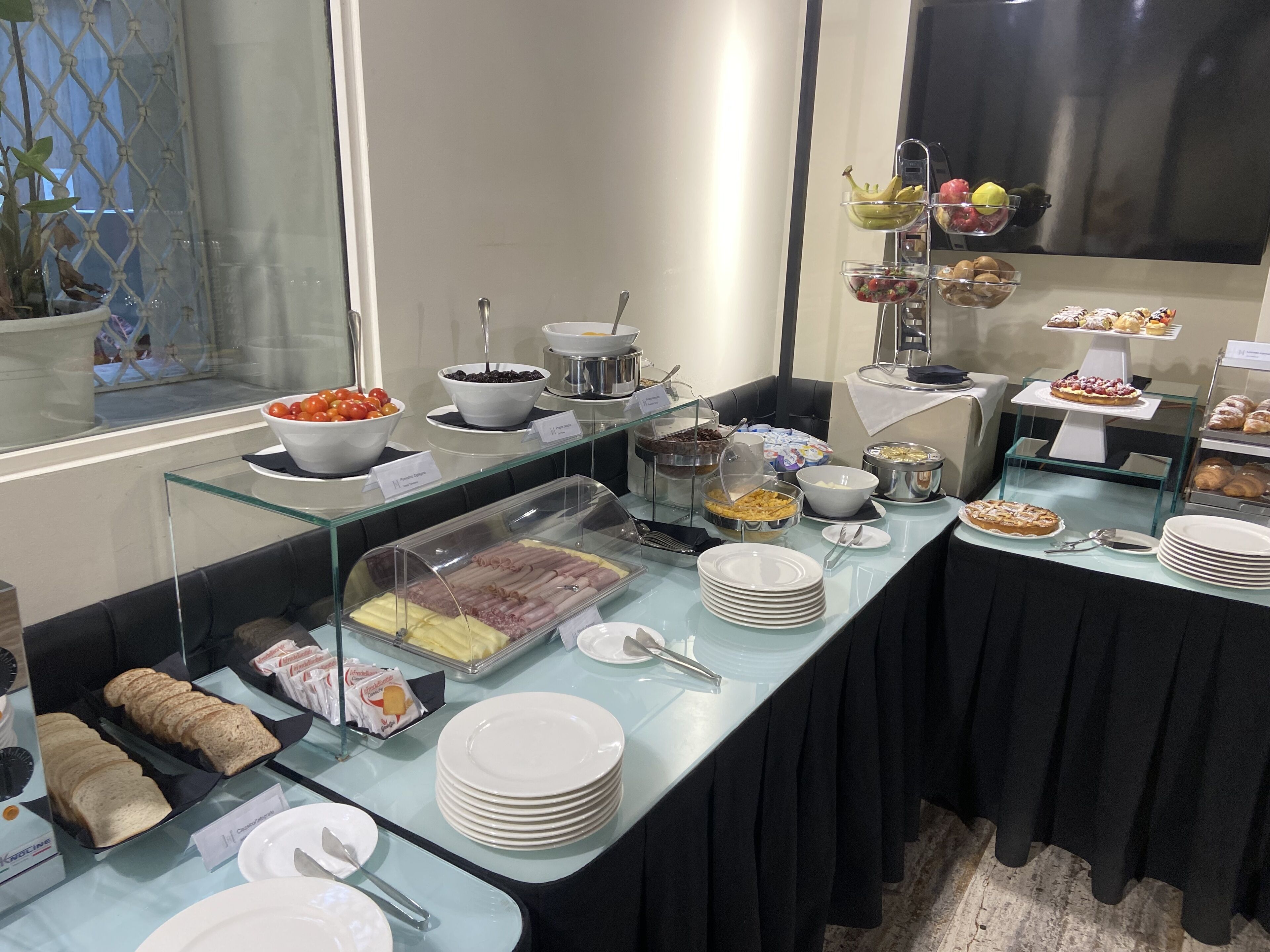 Un buffet con diversi cibi, tra cui frutta, formaggi e dolci.