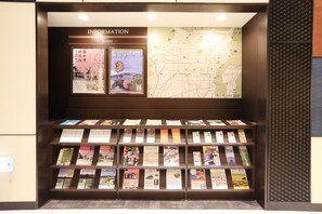 Une collection de brochures de voyage et une carte sont exposées dans l’espace d’information de l’hôtel.