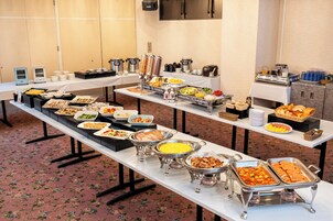 Uma mesa de buffet com diversos alimentos e utensílios de servir.
