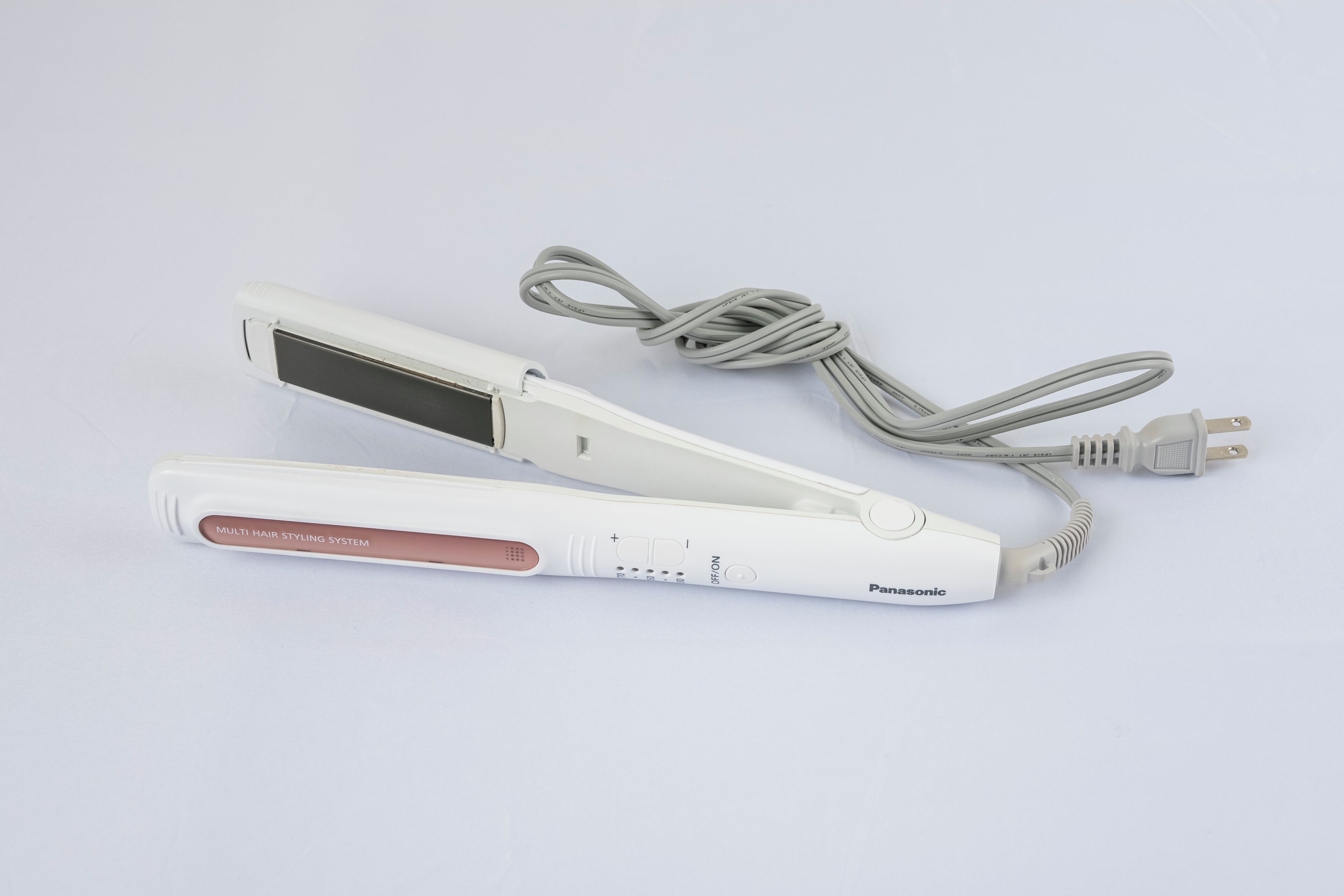 Un appareil de coiffure Panasonic avec un câble de chargement.