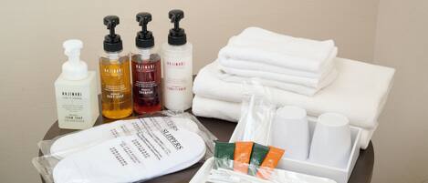 A neatly arranged bathroom with toiletries including body soap, body lotion, and shampoo.