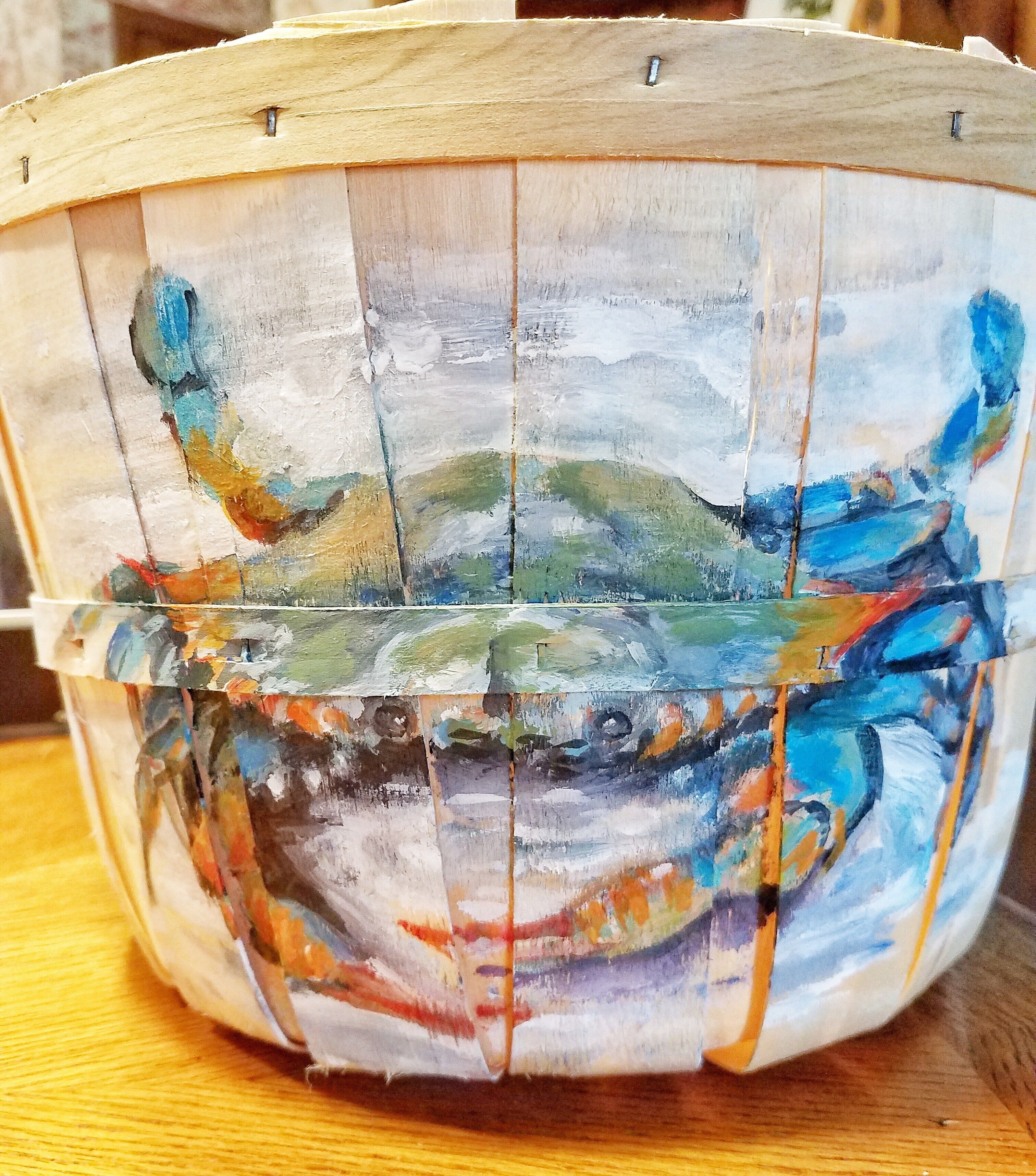A wooden basket with a painted design.