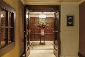 A hotel lobby with a wooden reception desk, a chandelier, and a sign that reads "La Vie." - Hilltop Hotel (Tokyo)