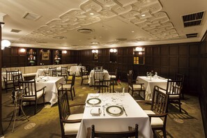 A formal dining room with multiple tables set for service, elegant ceiling design, and classic furniture. - Hilltop Hotel (Tokyo)