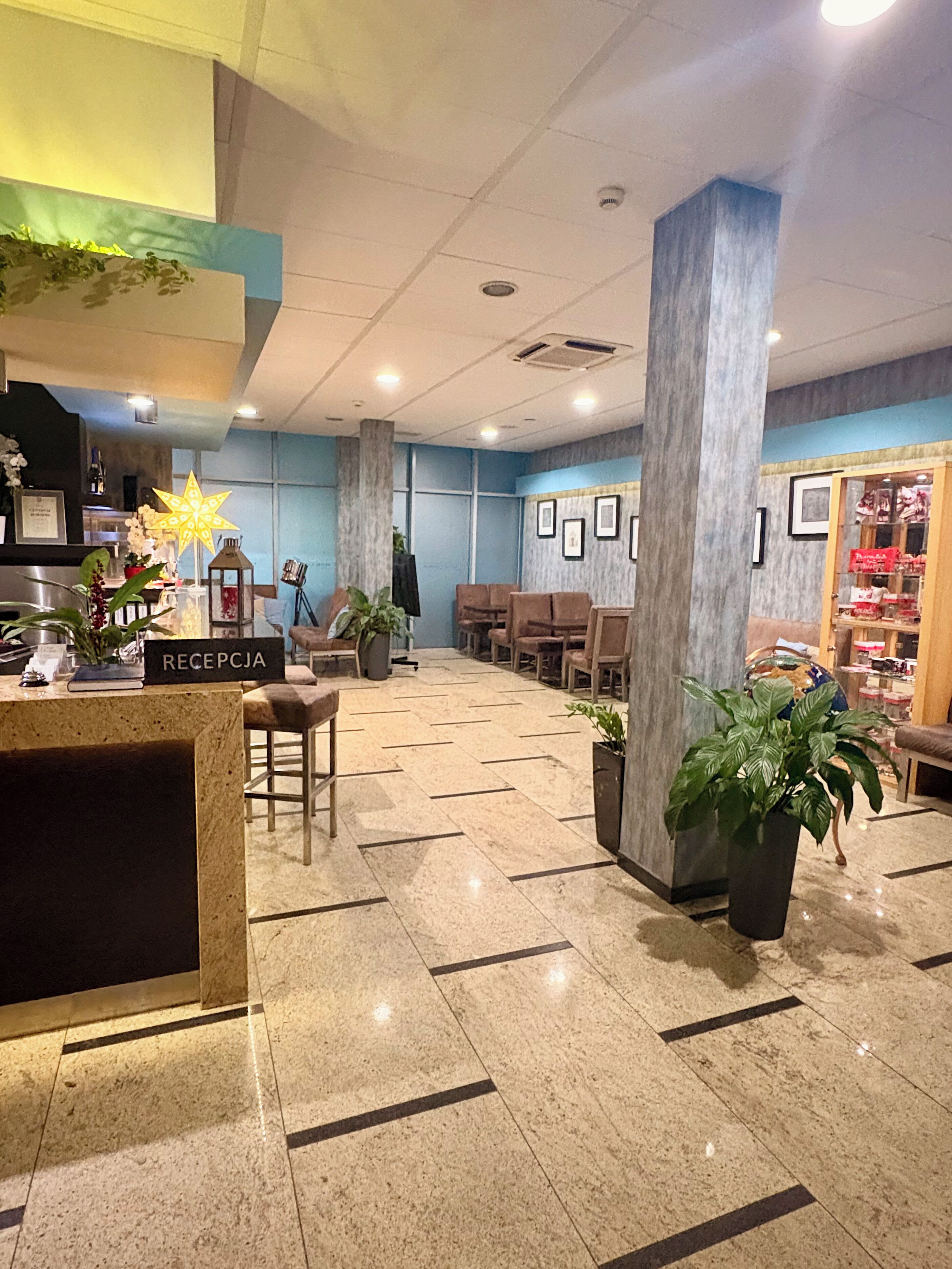 Eine Lobby mit Empfangsschalter, Sitzgelegenheiten und einer Vitrine.