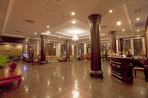 A spacious lobby with high ceilings, large columns, and a chandelier. There are seating areas and a reception desk. - Lucky Angkor Hotel & Spa (Siem Reap)