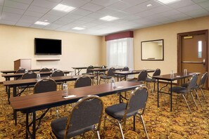 A conference room with multiple tables and chairs, a flat-screen TV, and a large mirror on the wall. - Country Inn & Suites by Radisson, Bowling Green, KY (Bowling Green)