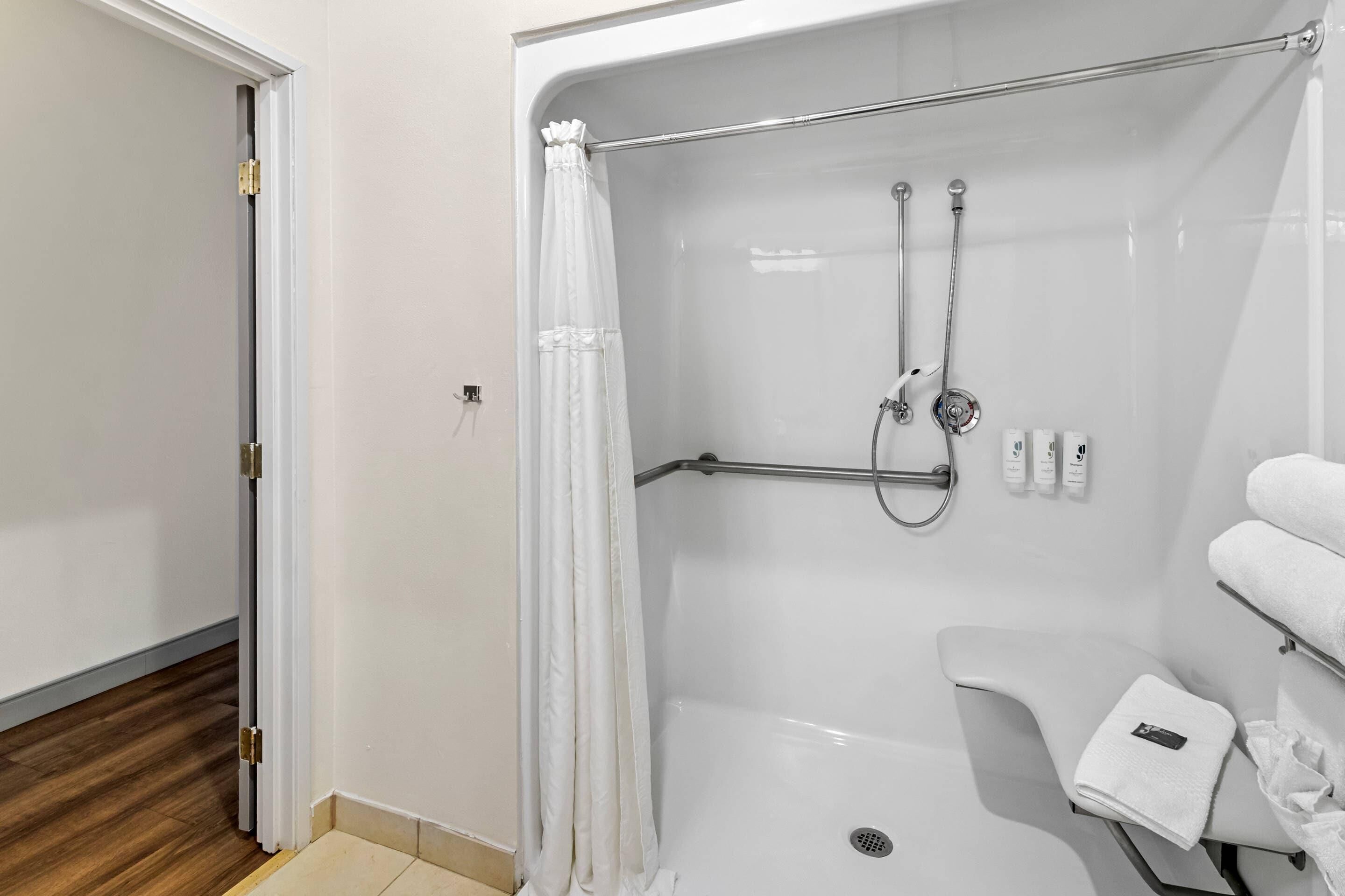 A modern bathroom with a shower, toilet, and a towel rack.