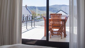 Una stanza con un'ampia porta-finestra scorrevole che si apre su un patio esterno.