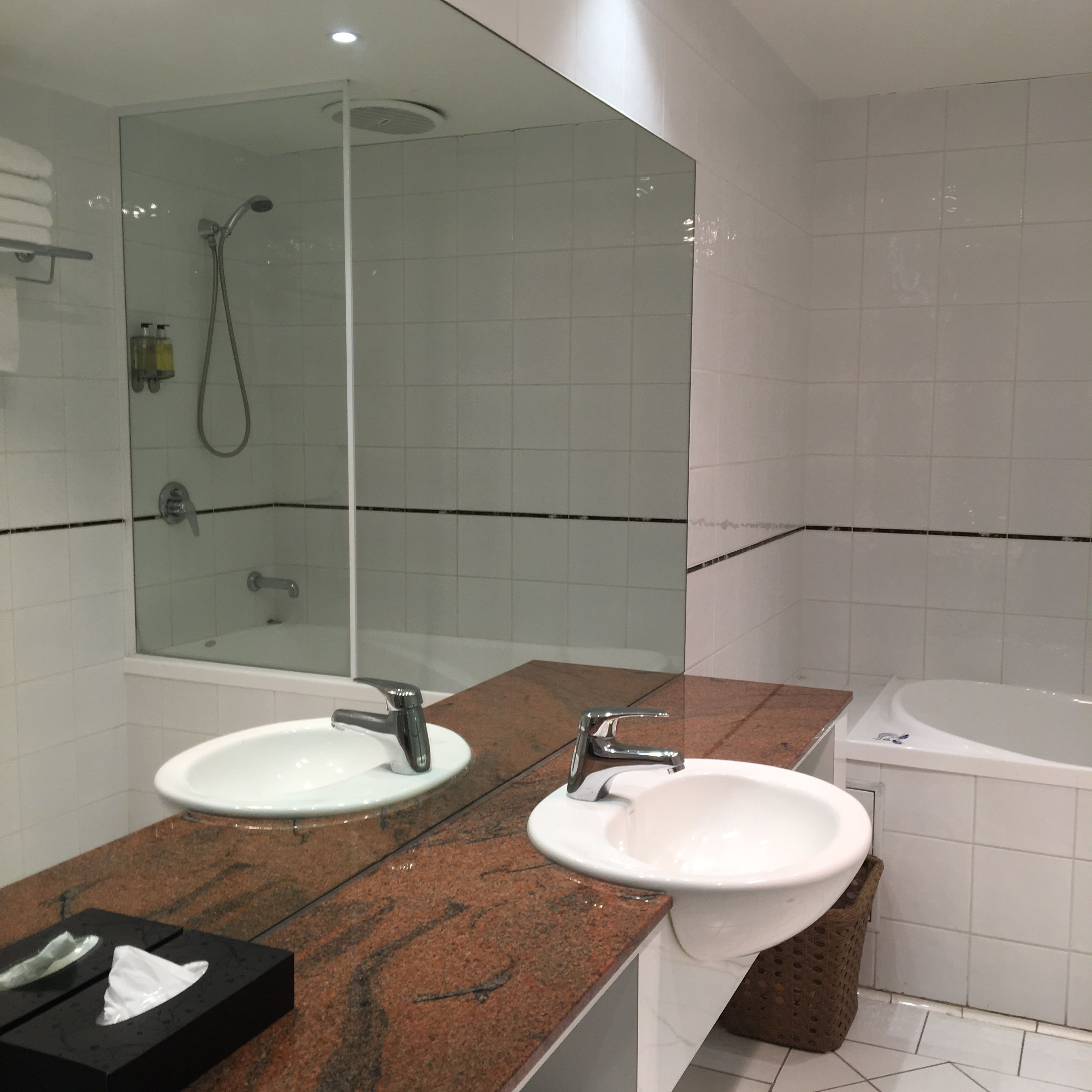 A bathroom with two sinks, a shower, and a bathtub.