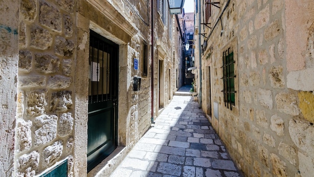 A narrow stone-paved alleyway between buildings with a sign for "Villa Flores" above. - Villa Flores - Apartments (Dubrovnik)
