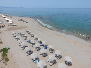 Aan het strand, ligstoelen aan het strand, parasols, een strandbar