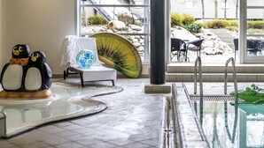 A pool area with a penguin sculpture, a covered table, and a view of the outside.