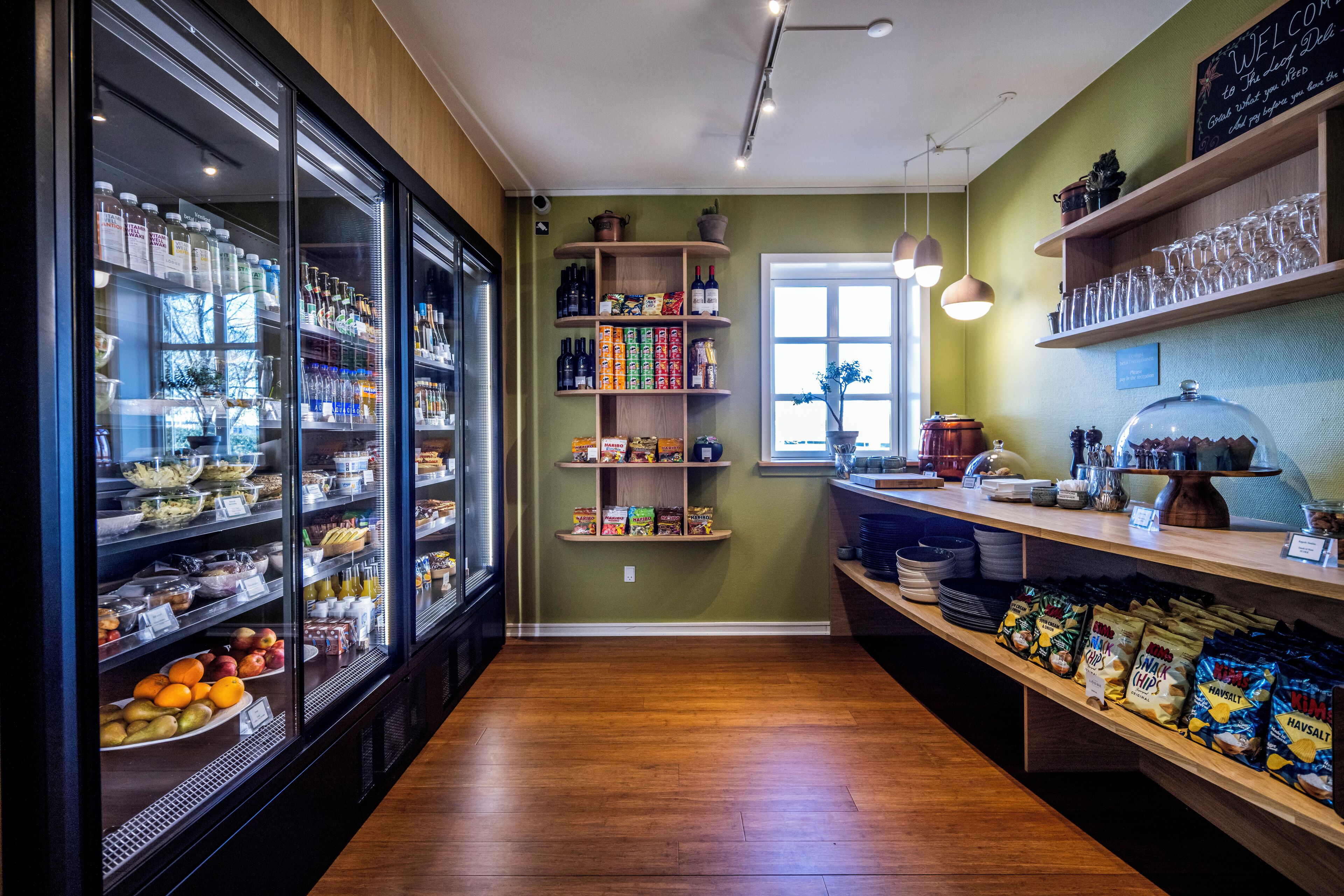 A bakery with shelves of baked goods, a display case with pastries, and a counter with snacks.