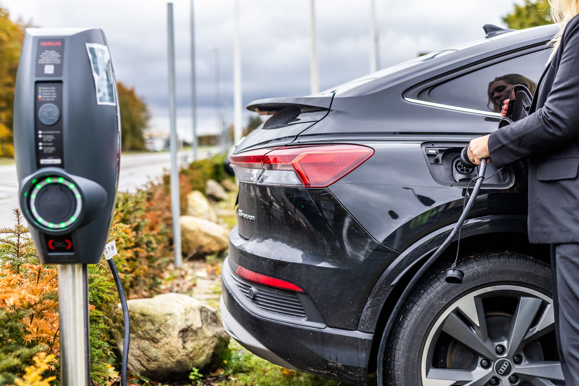 En svart SUV stod parkerad vid en laddstation för elfordon.