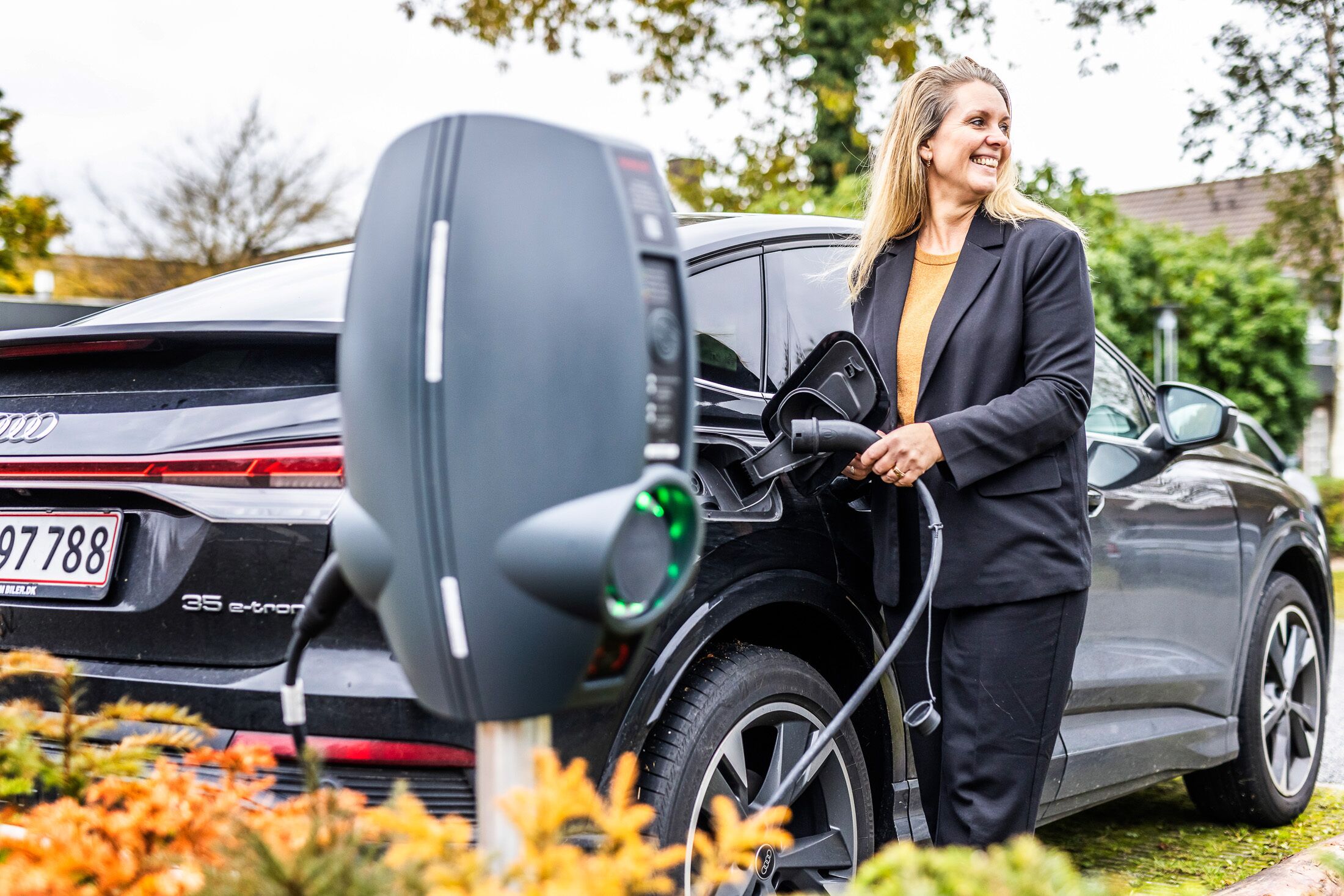 A person charging an electric vehicle at a charging station.