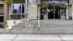 A modern building with a brick facade, large windows, and a sign reading "The Lodge."